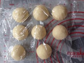 面团取出，排气，分成8等份，滚圆，盖上保鲜膜，静置15分钟