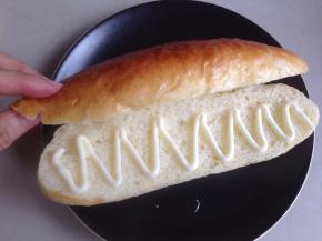 热狗从中间切开不切断，挤入沙拉酱