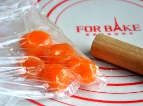 将蒸熟的咸蛋黄装保鲜袋中。