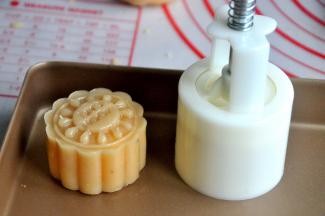 将包好的月饼放入50克的月饼模中，轻轻一压，月饼的雏形就有了。