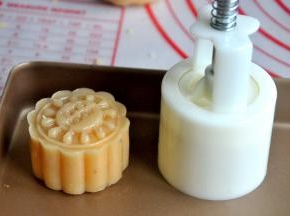 将包好的月饼放入50克的月饼模中，轻轻一压，月饼的雏形就有了。