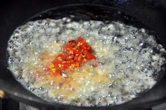 接着放入泡椒，翻炒几下，泡椒起到提味的作用，其实并不怎么辣，普通人都可以食用。