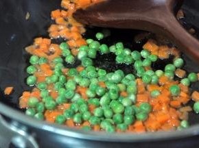 接着倒入青豆，快速翻炒几下。