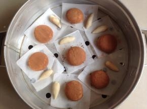然后放入到蒸笼里，将小面团搓成一头尖一头圆的小长条，也放在油纸上