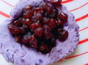 取一小块面团，用手掌心压扁，包上蜜豆。收口朝下。