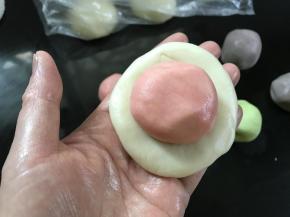 把一个油皮面团按扁，放入一个油酥面团。