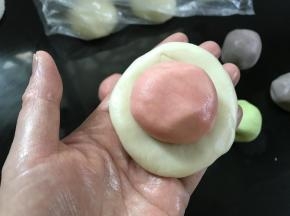 把一个油皮面团按扁，放入一个油酥面团。