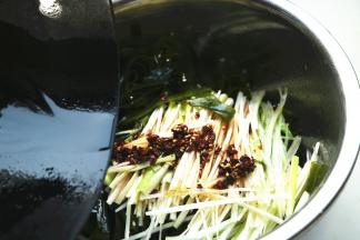 炒锅加15克花生油和5克芝麻油，加入一些花椒，烧热后浇在葱上，激出葱的香味。