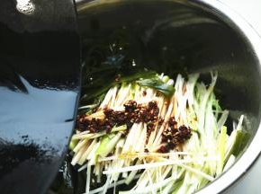 炒锅加15克花生油和5克芝麻油，加入一些花椒，烧热后浇在葱上，激出葱的香味。