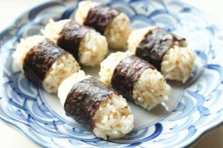 取适量拌好的米饭，整理成饭团形状，用海苔包起来，饭团就做好了。