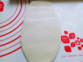 取一面团，用掌心轻轻按压，再用擀面杖来回擀长舌状。