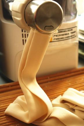 面粉放入面条机，开启劲道面条程序，缓缓加入清水，做出劲道的面片。