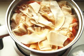 炒好的西红柿放入汤锅，加适量水，煮开后下入面片。