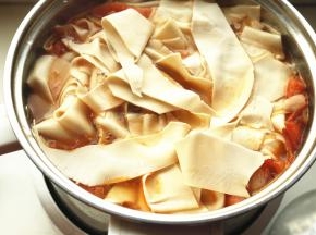 炒好的西红柿放入汤锅，加适量水，煮开后下入面片。