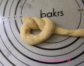 将面条的一头打成活结，另一端从圆圈里绕出；