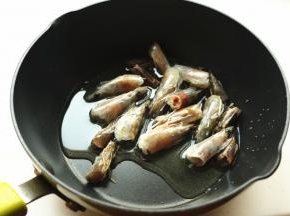 开始熬制虾油。炒锅加油放入虾头开始炒。