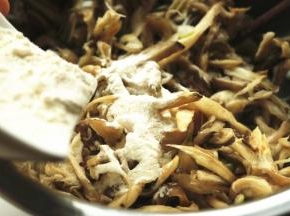 蘑菇腌制一会，变的略微软，加入面粉拌匀，加入面粉可以使饼比较结实，不易散开。