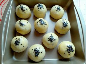 刷好蛋液的蛋黄酥上面撒上撒上黑芝麻，撒好芝麻后还可以再刷一层蛋液。