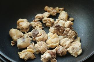 炒锅不放油，下入鸡腿开始煸炒。