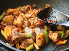 下入冰糖继续翻炒。