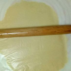 面团上垫上油纸，用擀面杖擀薄，约3mm左右