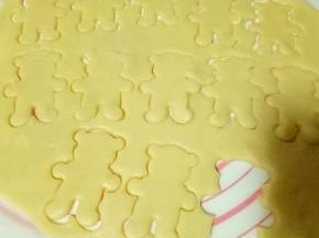 全部压完后，小心得取下小熊，放在铺好的锡纸烤盘中，炒上多余下来的面皮再揉成团重做步骤，依次完成。