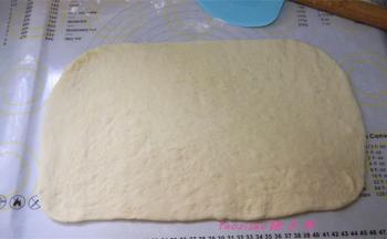 将发好的面团倒在揉面的硅胶垫上，擀成长方形面片；