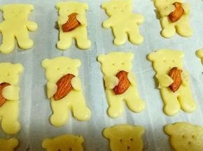 小熊的手抱住杏仁就完成了。全部完成。
烤箱170度预热5分钟，烤盘入烤箱中层，170度上下火烤10-12分钟(注意观察颜色，根据自家烤箱性能另定温度)