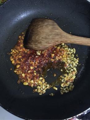 锅烧热倒入适量的油，放入蒜蓉和红油豆瓣酱炸出香味儿来。

