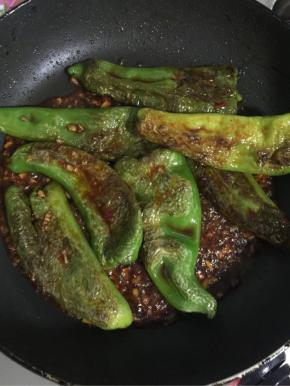 倒入煎好的薄皮青椒翻炒均匀，使青椒能够均匀的裹满料汁儿！
