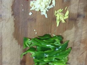青椒去蒂清洗干净后切成块儿，生姜切成丝，蒜瓣剥皮剁碎，干辣椒切成段备用！
