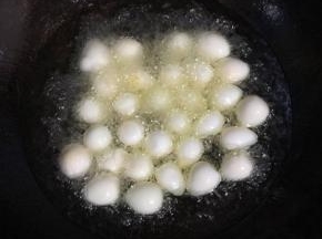 锅中放入适量的油，烧至六成热时，放入鹌鹑蛋中小火慢炸。

