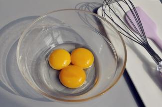 取一个无油无水的玻璃碗，加入蛋黄和玉米油。