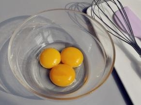 取一个无油无水的玻璃碗，加入蛋黄和玉米油。