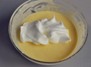 将3分之1的蛋白舀入蛋黄糊中，翻拌至完全融合。