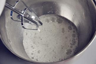 取一个无油无水的打蛋盆，将蛋清倒入，打发至鱼眼状时加入第一次糖。