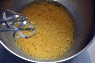 取4个常温鸡蛋，放入打蛋盆中，为了更好的打发全蛋，在地下坐一盆温水，分三次加入细砂糖打发，鱼眼状加入第一次。