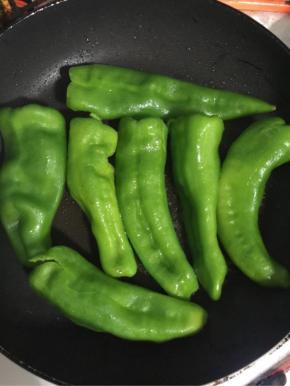 锅烧热，放入适量的油，把擦干水分的薄皮青椒放进去中小火慢慢的煎！
