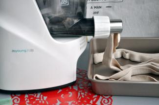 启动快速面条的功能后，将水杯卡在面条机上，确保水进入了面条机，随着机器的不断搅拌，面条机开始出面皮。