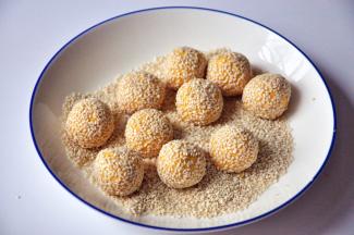 将小球在白芝麻中滚一圈，轻轻粘上芝麻。