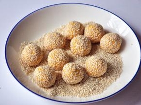 将小球在白芝麻中滚一圈，轻轻粘上芝麻。