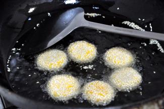 锅中倒入适量的玉米油，油烧到5成后依次放入锅中炸至飘起，反复按压几次，麻饼会变大中间产生空心。