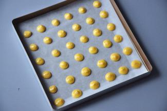 为了方便脱模，在法焙客金盘中垫油纸，在上面挤出圆形面糊，注意要留一定间距。