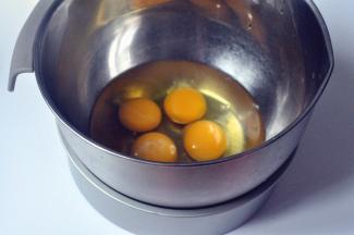 取4个常温鸡蛋，放入打蛋盆中，为了更好的打发全蛋，在底下坐一盆温水。