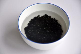 将黑豆浸泡2小时，黑芝麻洗净后放入平底锅中焙香。