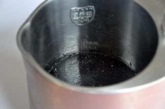 连同泡过黑豆的水和黑芝麻，一起倒入豆浆机中，盖住最低水位线。