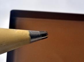 将三能中号18齿花嘴放入裱花袋，套入深口杯，将曲奇面糊倒入裱花袋中，并剪个小口。