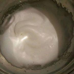 接着再用电动打蛋器继续高速打发，当蛋清泡沫消失，变得细腻顺滑的时候就可以再加入另外的三分之一糖粉。