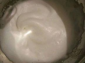 接着再用电动打蛋器继续高速打发，当蛋清泡沫消失，变得细腻顺滑的时候就可以再加入另外的三分之一糖粉。