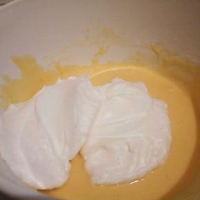  盛1/3蛋白到蛋黄碗里，翻拌均匀(从底部往上翻拌，不要画圈搅拌)。